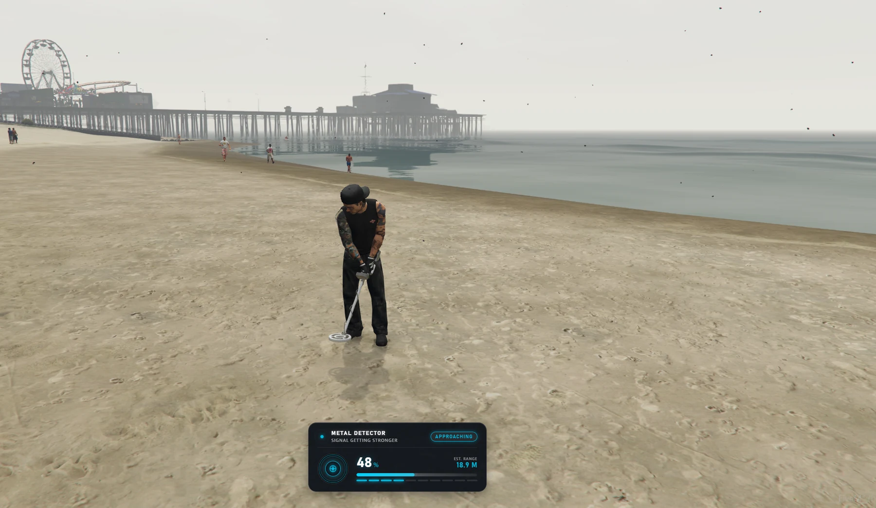 A player sweeping the beach with the metal detector
